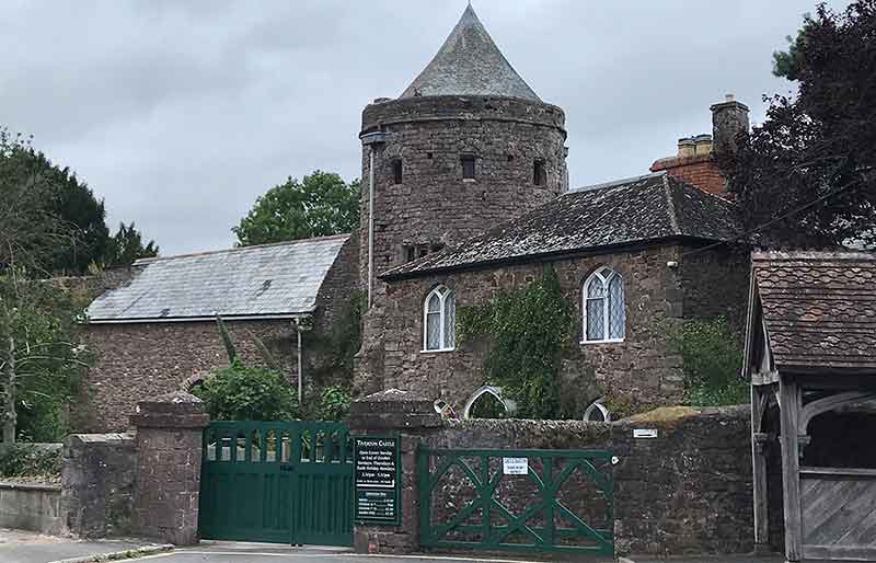 Exterior of stone buildings and round tower.