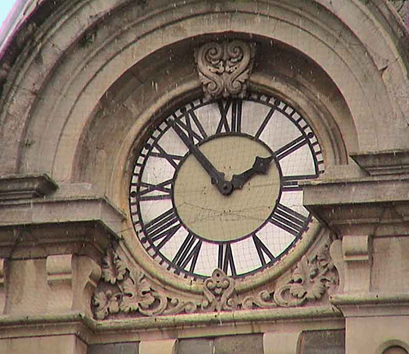 The clock with Roman numerals.