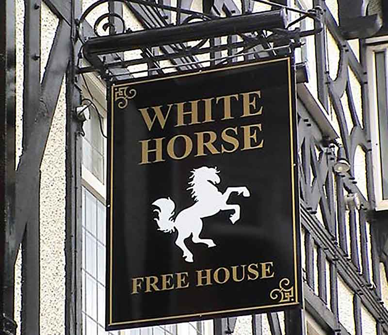 Rampant white horse on black pub sign with gold lettering.